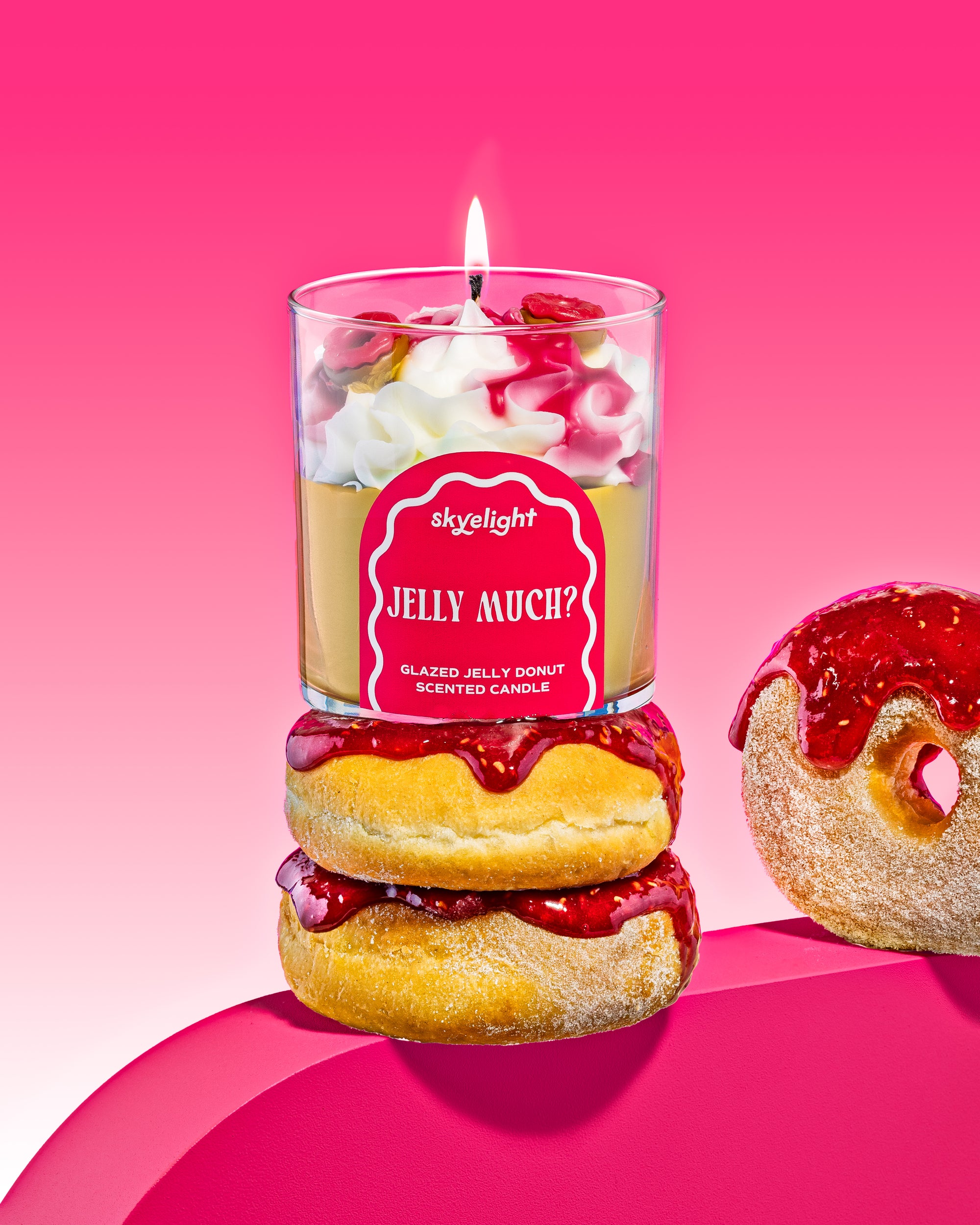 Scented candle with jelly donut design on a pink background